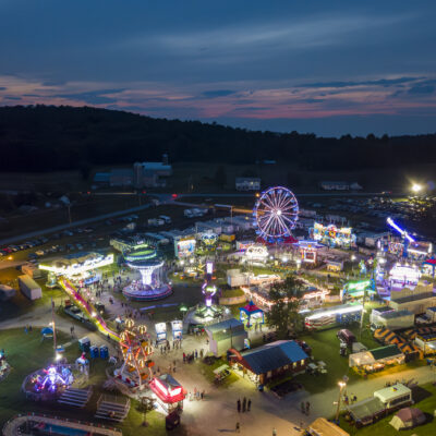 Twilight drone photo of the Addison County Fair and Field Days, New Haven, Vermont, a classic small country fair with Ferris Wheel and Midway.