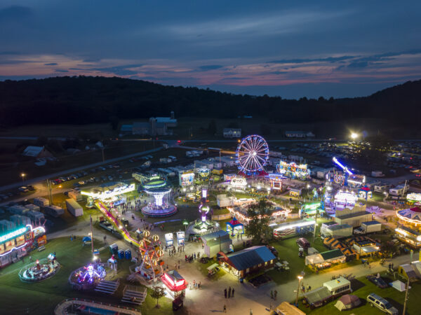 Twilight drone photo of the Addison County Fair and Field Days, New Haven, Vermont, a classic small country fair with Ferris Wheel and Midway.