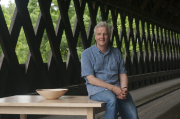 Vermont furniture maker Charles Shackleton with one of his bowls and naked tables at the Middle Bridge in Woodstock, Vermont. Vermont furniture maker Charles Shackleton with one of his bowls and naked tables at the Middle Bridge in Woodstock, Vermont.